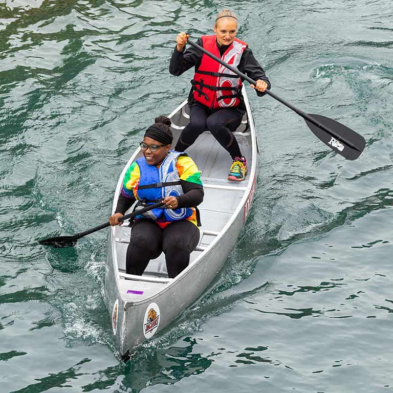 Two students row in their canoe.