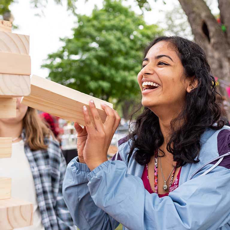 A student laughs as she plays giant Jenga.