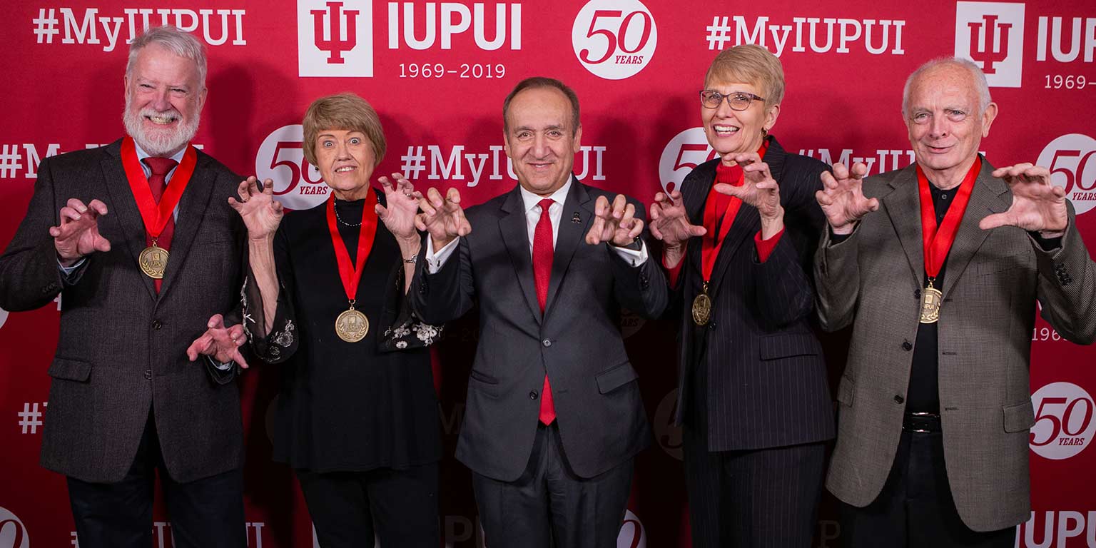 Chancellor's Medallion winners from the Toast to IUPUI stand with Chancellor Paydar at the photo booth.