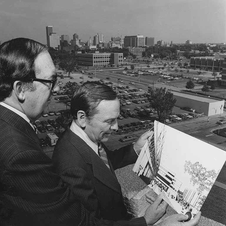 Former Chancellor Glenn Irwin looks over an artist's rendering of the Business/SPEA Building.