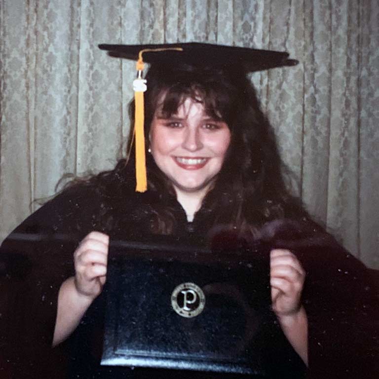 Kim Merritt holds up her diploma folder when she graduated from IUPUI in 1995.