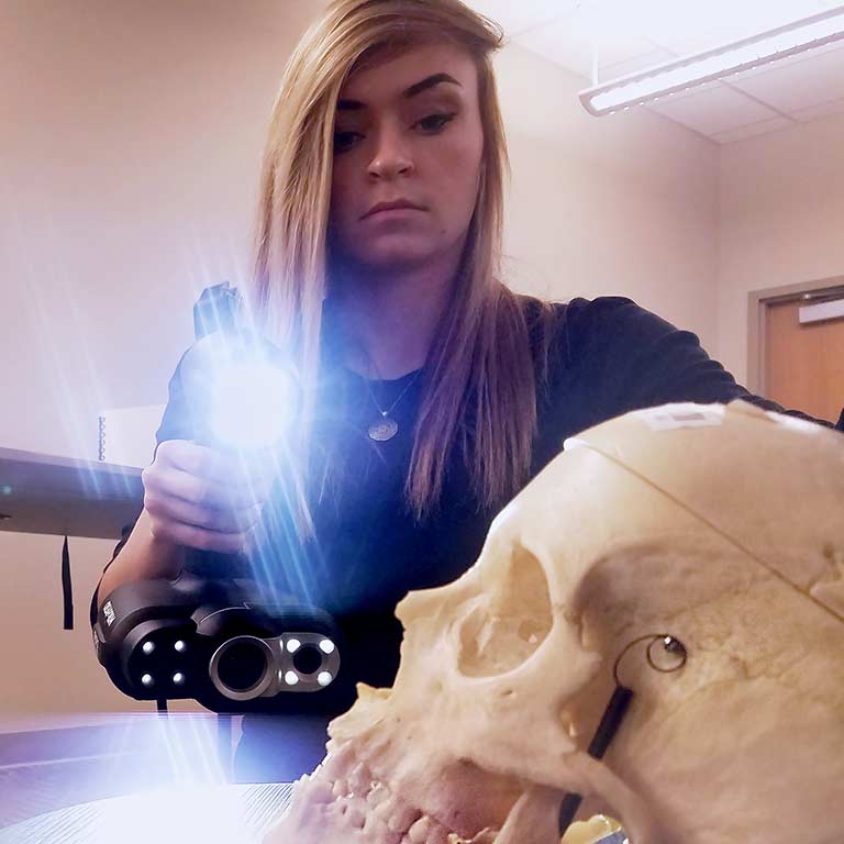 Jordan Nelsen takes a 3-D scan of a skull.